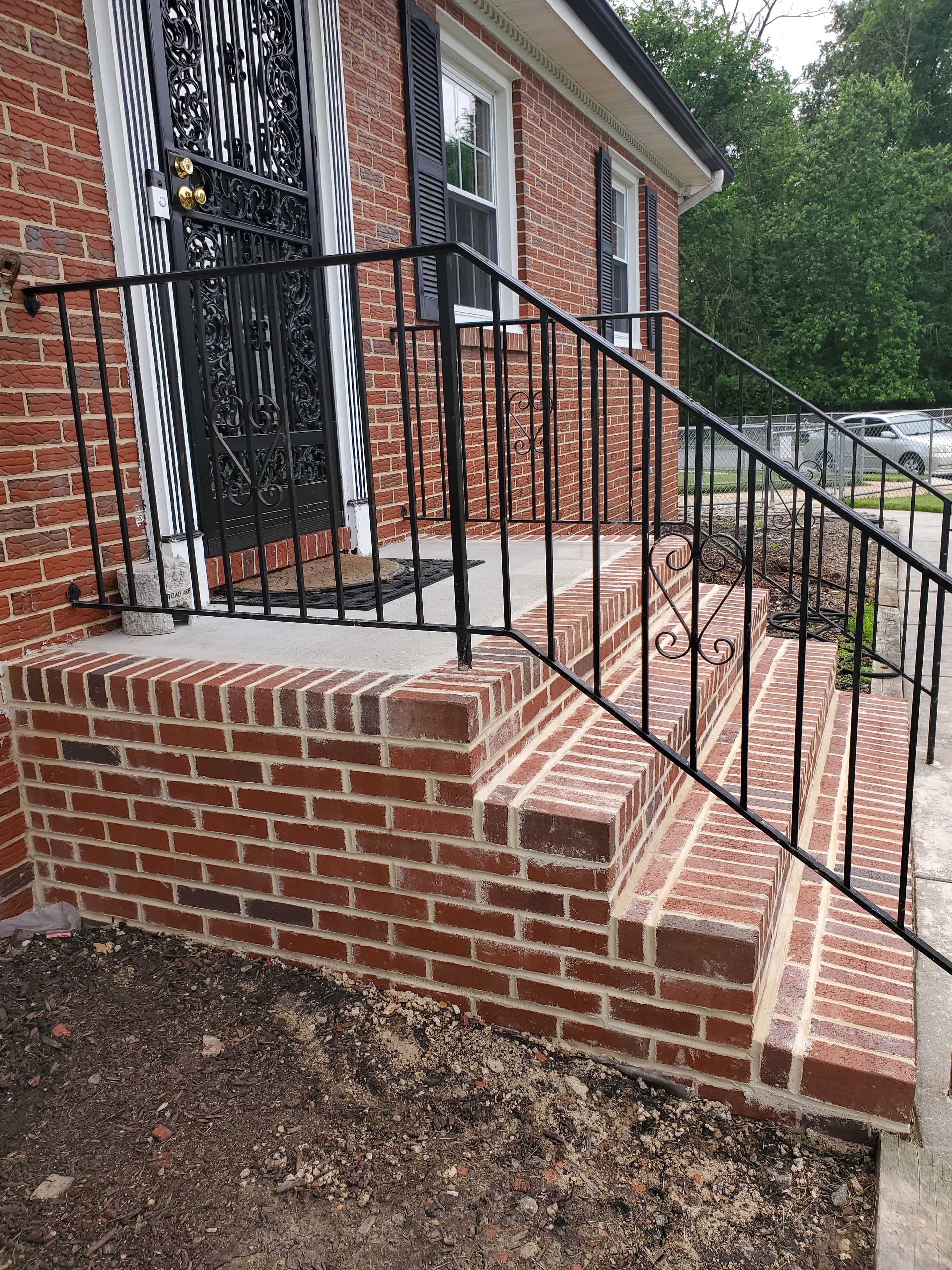 After: restored brick entrance with black railings