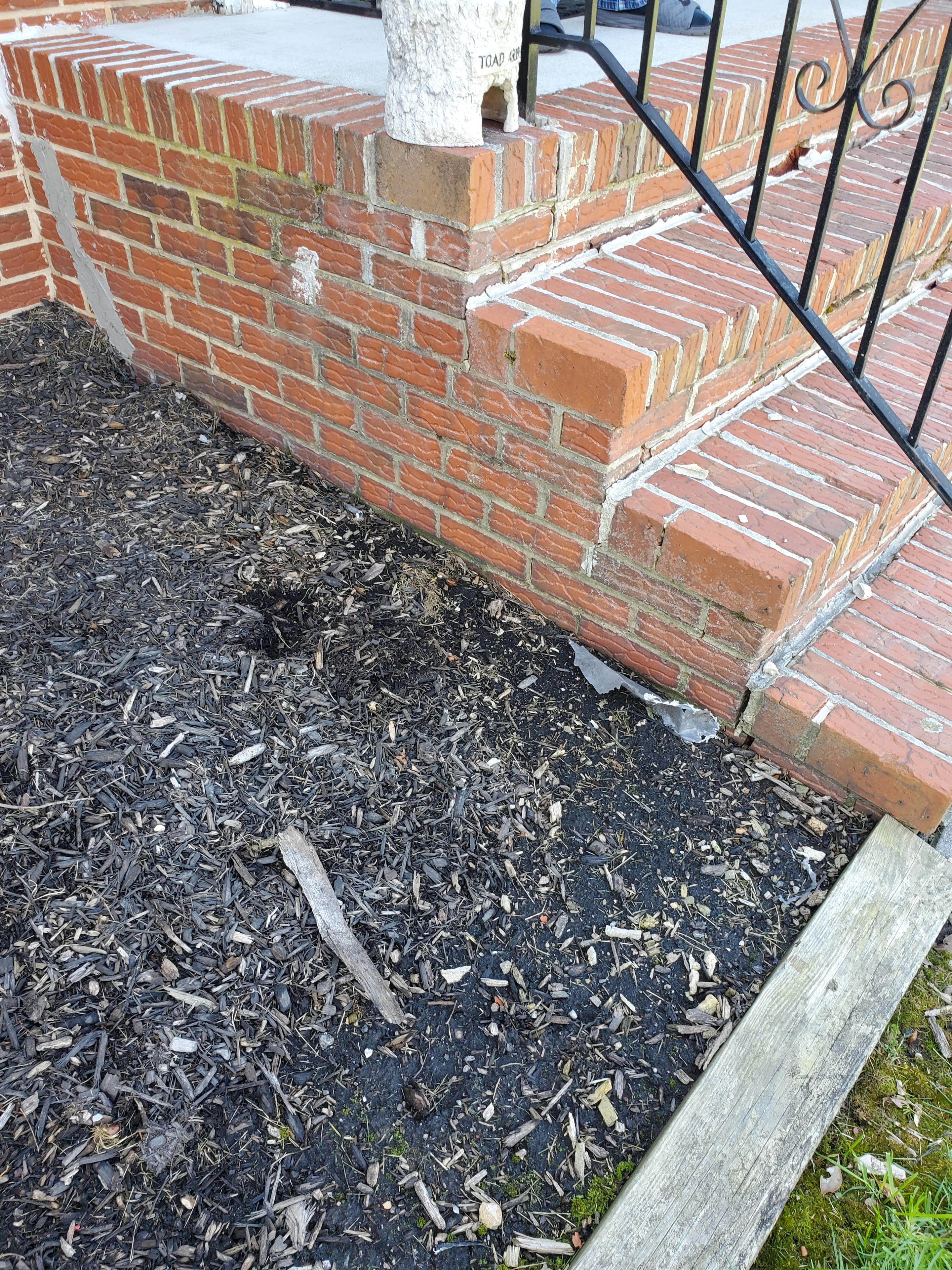 Before: worn brick entrance wall and landscaping
