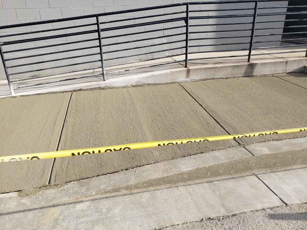 New commercial concrete sidewalk beside a railing