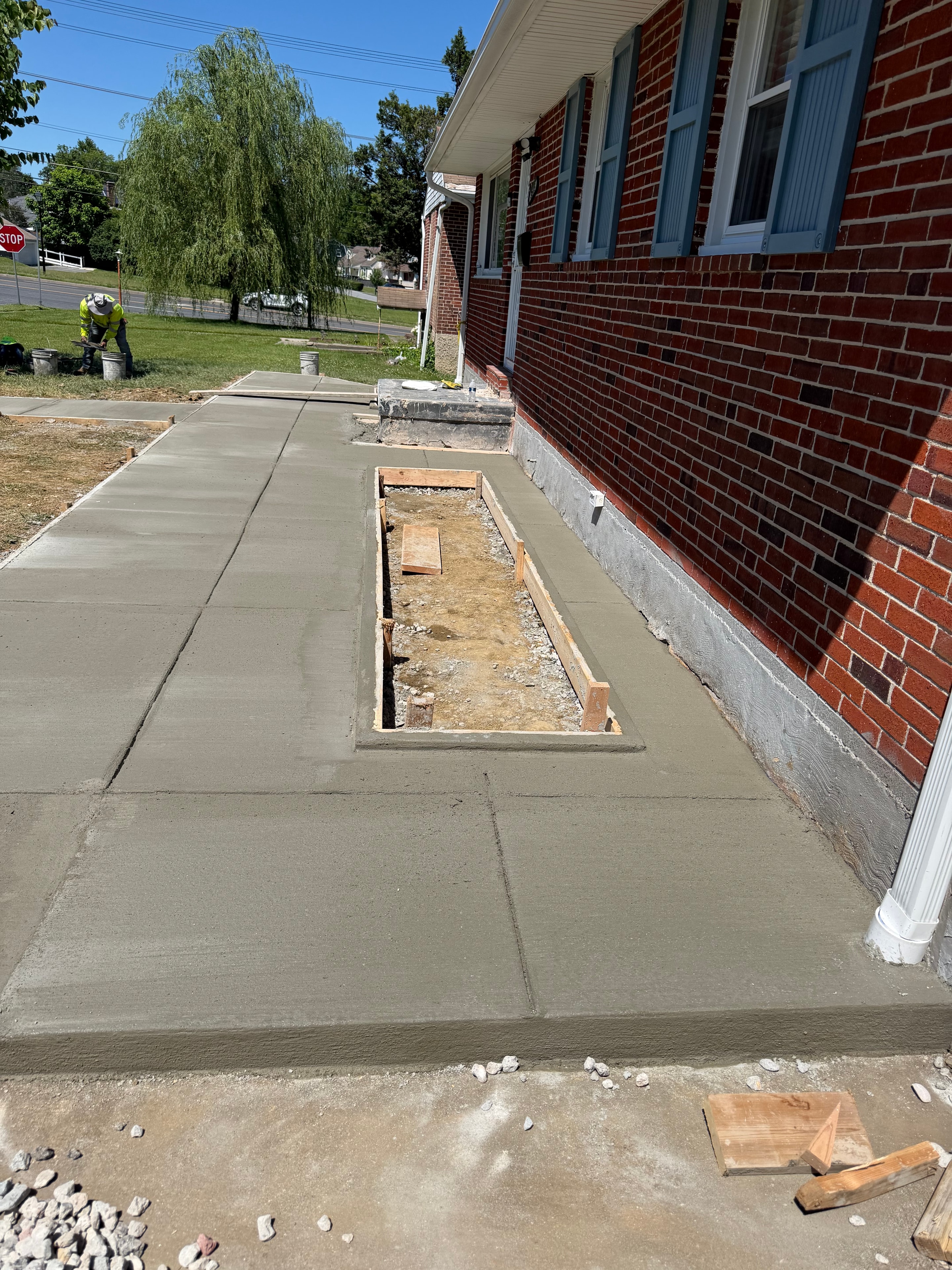 Fresh concrete sidewalk pour beside a brick building