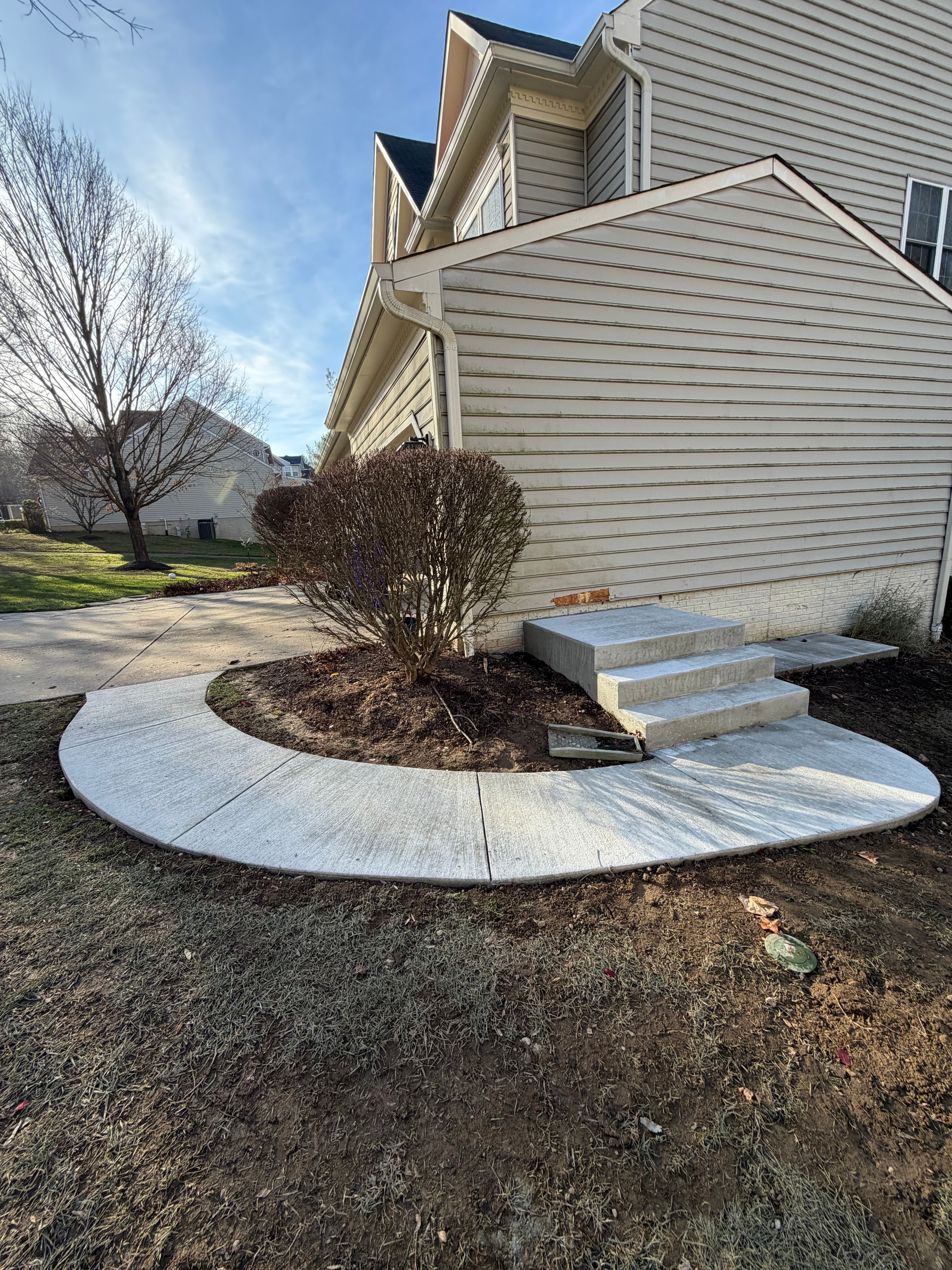 Curved concrete walkway and steps at a residential home