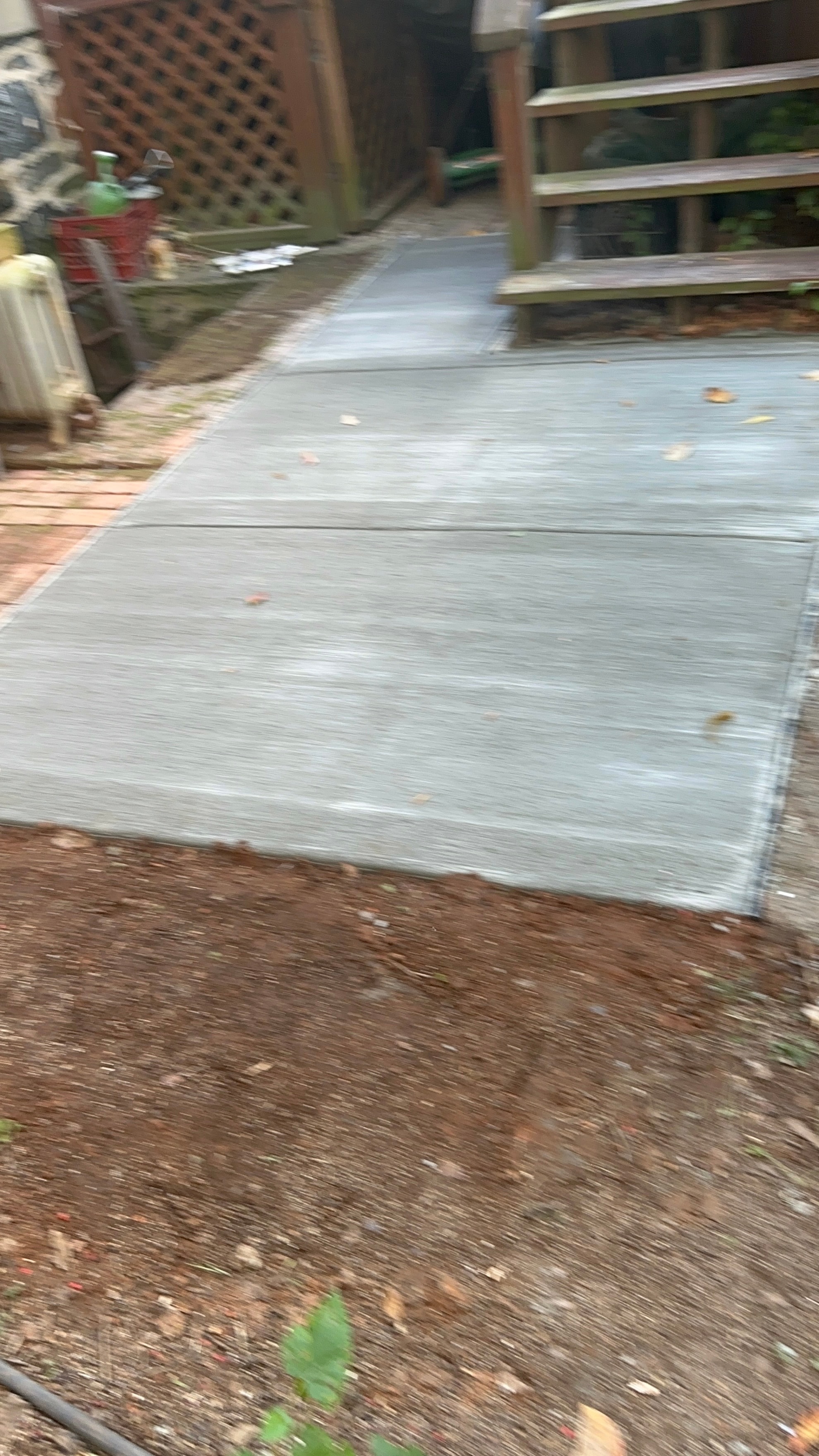 Fresh concrete patio walkway beside a residential deck