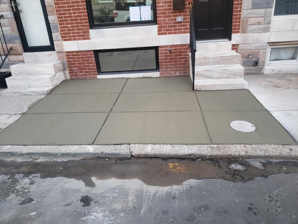 New concrete sidewalk in front of residential row homes
