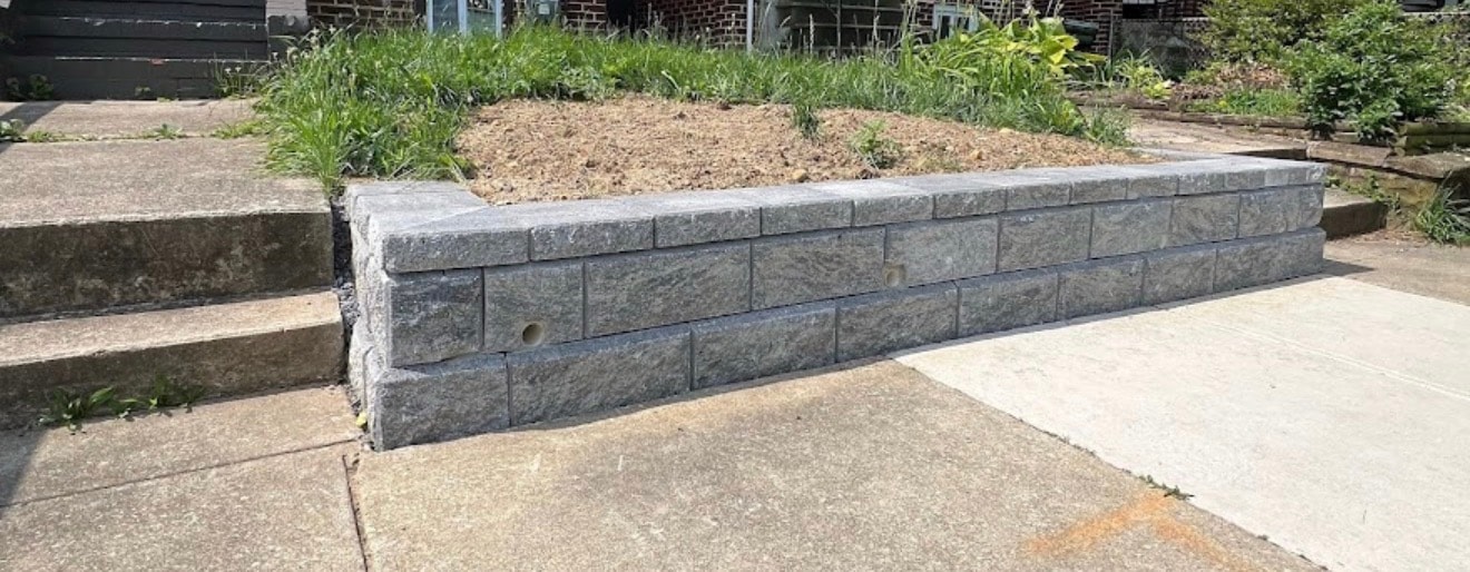 Gray stone retaining wall beside a residential walkway