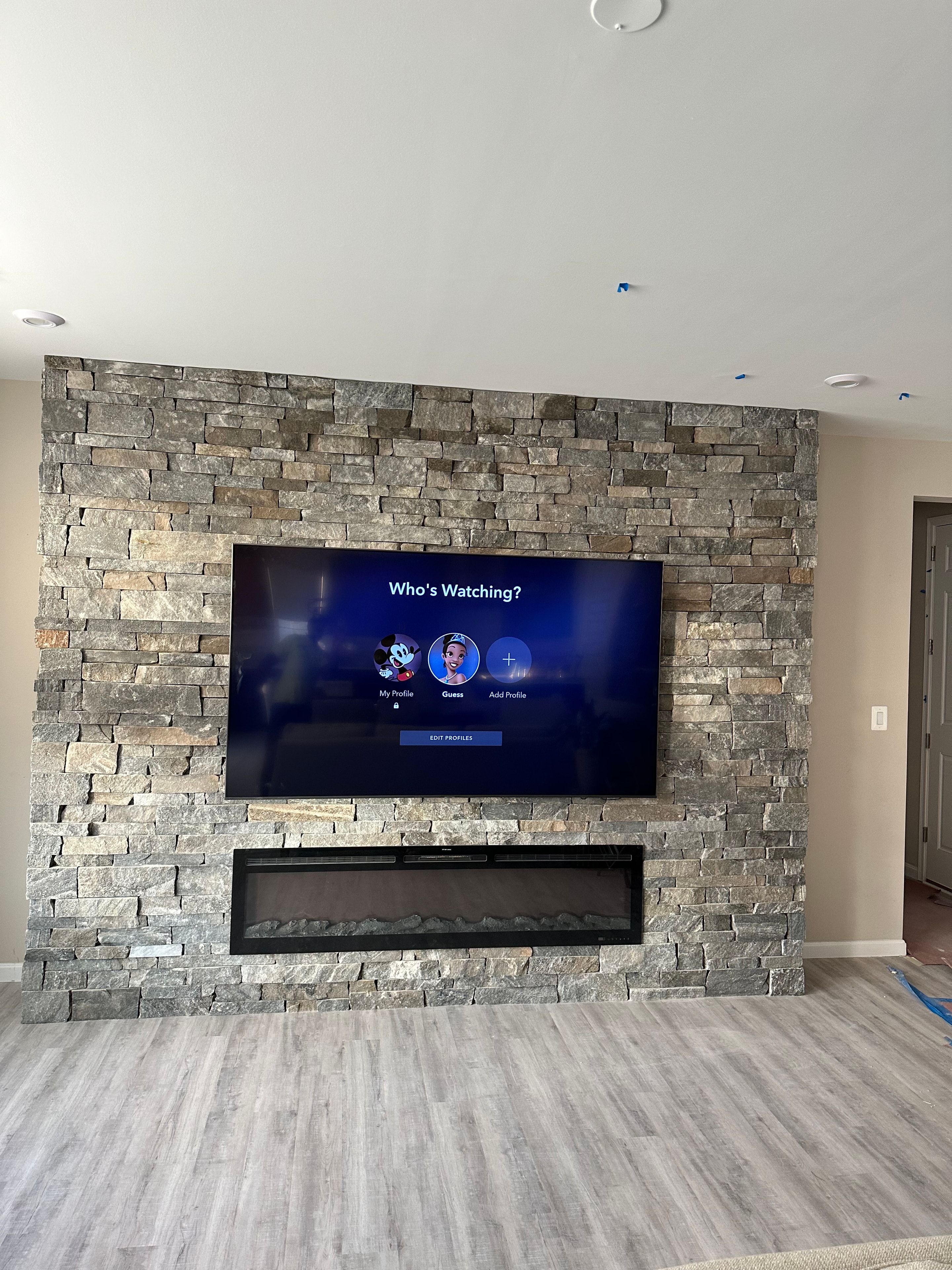Interior stone veneer fireplace and television feature wall